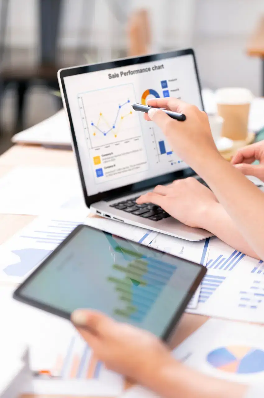 SEO specialist analyzing keyword research data and sales performance charts on laptop during content planning phase