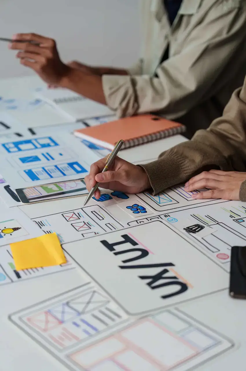 Designer sketching UI/UX wireframes on paper during the research and strategy phase